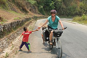 Sandra greeting a kid by the roadside in Laos.