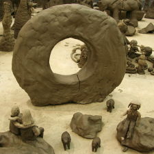 Imaginary clay scene of three people in front of the Men-an-tol stone in Cornwall.