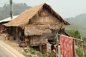 A typical bamboo hut in a Lao village, modernized with a satellite TV receiver.