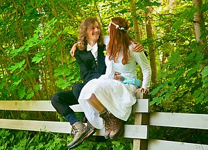 Wedding portrait sitting on the fence. Photo by Panu Hällfors.